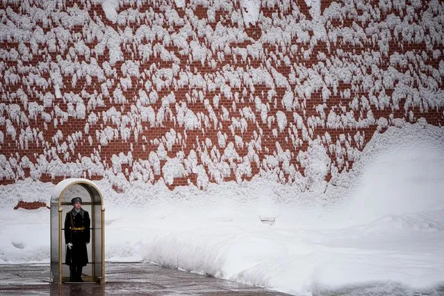 A soldier of the Kremlin guard stands at the Tomb of Unknown Soldier at the Kremlin Wall after a snowfall in Moscow, Russia, Monday, February 7, 2022. (Photo by Alexander Zemlianichenko/AP Photo)