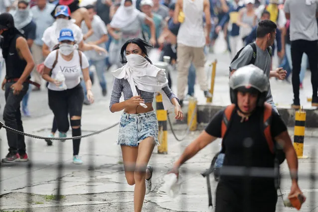 Demonstrators run away while clashing with riot police during a rally against Venezuela's President Nicolas Maduro's government in Caracas, Venezuela April 10, 2017. (Photo by Christian Veron/Reuters)