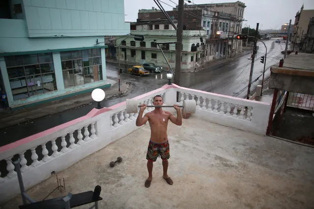 Painter Dian Peralta, 24, exercises on the roof of his home in downtown Havana, Cuba, May 10, 2016. (Photo by Alexandre Meneghini/Reuters)