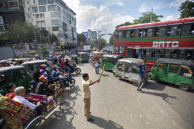 Volunteers manage road traffic in Dhaka, Bangladesh, Tuesday, August 6, 2024. (Photo by Rajib Dhar/AP Photo)