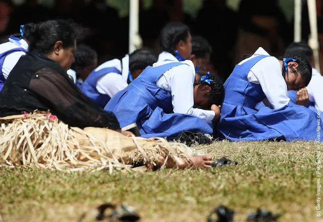 School girls taking part in the royal funeral struggle in the heat during the State Funeral held for King George Tupou V at Mala'ekula