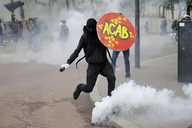 A masked protestor kicks a tear gas canister during a demonstration to protest the government's proposed labour law reforms in Nantes, France, June 2, 2016. (Photo by Stephane Mahe/Reuters)
