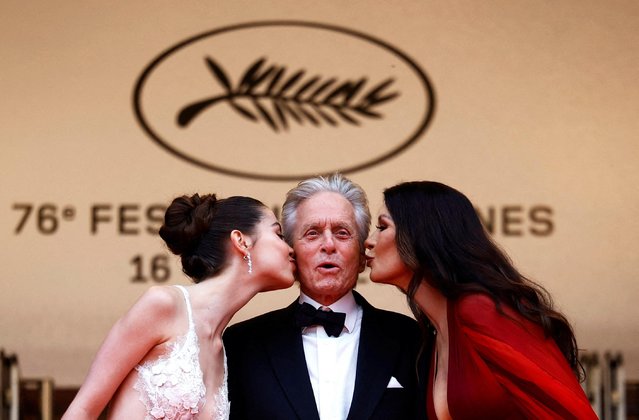 British actress Catherine Zeta-Jones (R) and her daughter Carys kiss US actor Michael Douglas on the cheek as they arrive for the opening ceremony and the screening of the film “Jeanne du Barry” during the 76th edition of the Cannes Film Festival in Cannes, southern France, on May 16, 2023. (Photo by Sarah Meyssonnier/Reuters)