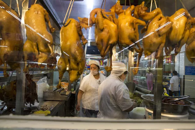 In this Wednesday, November 11, 2015, photo, a worker prepares cooked ducks for sale at a Wal-Mart in Shenzhen, in southern China's Guangdong province. If Arkansas-based Wal-Mart wants to win over foreign consumers, it has to shed some of its American ways, and cater to very different customs and conventions. China is the ultimate prize. (Photo by Ng Han Guan/AP Photo)