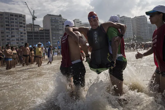 Krige Schabort of the United States, is carried out of the water at Copacabana Beach as he competes in the men's PT1 Paralympic Triathlon test event in Rio de Janeiro, Brazil, Saturday, August 1, 2015. (Photo by Felipe Dana/AP Photo)