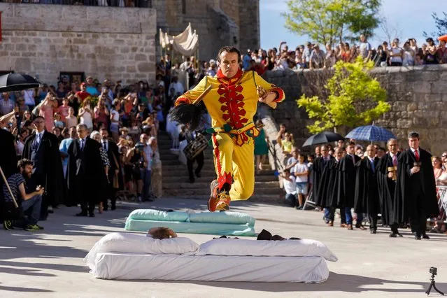 A man dressed up as the devil jumps over babies lying on a mattress in the street during “El Colacho”, the “baby jumping festival” in the village of Castrillo de Murcia, near Burgos on June 18, 2017. (Photo by Cesar Manso/AFP Photo)