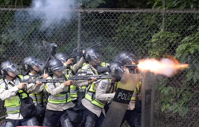 Riot police fire rubber bullets and tear gas grenades at students from the public Central University of Venezuela who demonstrate in demand of the referendum on removing President Nicolas Maduro in Caracas on June 9, 2016. (Photo by Federico Parra/AFP Photo)