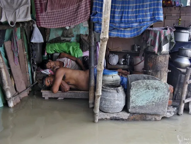 Local residents sleep inside a flooded hut after heavy monsoon rains in the eastern India caused the rise in water levels of river Ganga and its tributaries in Kolkata, India, August 3, 2015. (Photo by Rupak De Chowdhuri/Reuters)