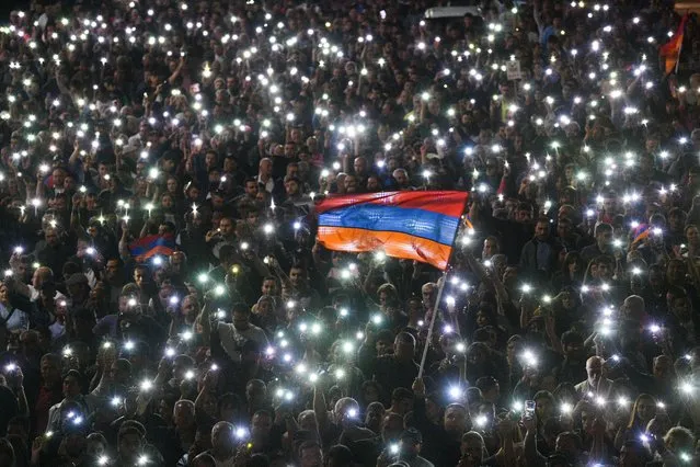 Protesters shine their mobile torches as they march down a street during an opposition protest in central Yerevan, Armenia on May 25, 2022. Opposition is protesting against the 24 May trilateral meeting between meeting between Armenia's Prime Minister Pashinyan, Azerbaijan's President Aliyev and European Council President Michel in Brussels, in which the parties didn't discuss the issue of Nagorno Karabakh. Pashinyan's opponents believe that this indicates that the Armenian authorities have agreed that the disputed territory of Nagorno Karabakh remains as part of Azerbaijan. Opposition protests have been taking place across Armenia since 25 April. (Photo by Alexander Patrin/TASS)