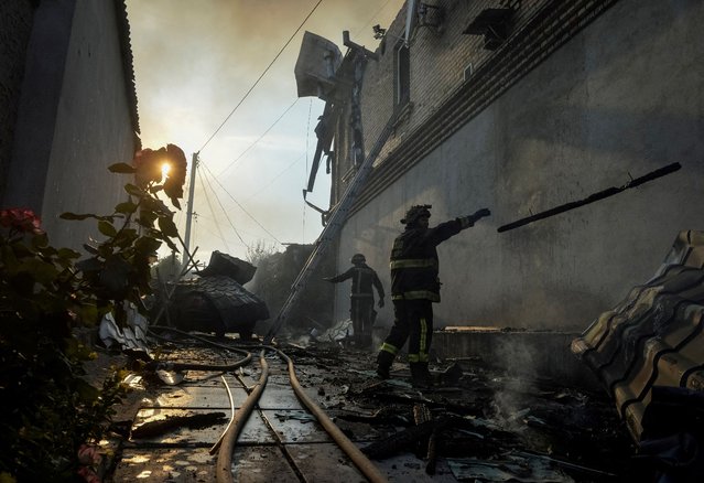 Rescuers work at a site of a private house heavily damaged in a Russian shelling, during the evacuation of local residents from a flooded area after the Nova Kakhovka dam breached, amid Russia's attack on Ukraine, in Kherson, Ukraine on June 9, 2023. (Photo by Oleksandr Klymenko/Reuters)