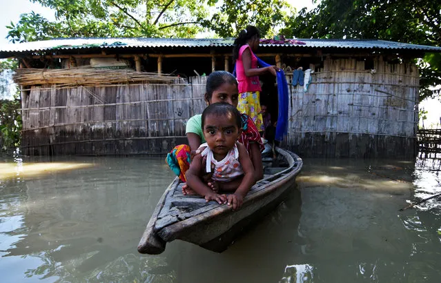 Villagers use a boat as they try to move to safer places at a flood-affected village in Darrang district in the northeastern state of Assam, India July 14, 2017. Floods in India's northeast have killed at least 83 people and led to the death of three rare one-horned rhinoceros at a national park that has the world's largest concentration of the species. (Photo by Anuwar Hazarika/Reuters)