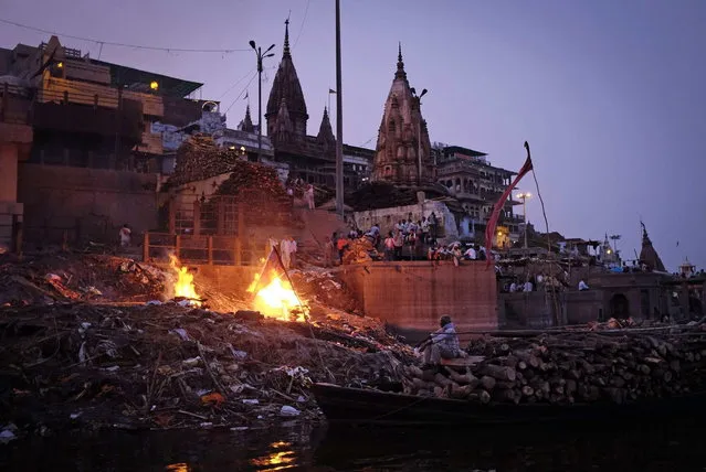 People watch as pyres burn at a cremation ground on the banks of river Ganges in Varanasi, in the northern Indian state of Uttar Pradesh, June 19, 2014. (Photo by Danish Siddiqui/Reuters)