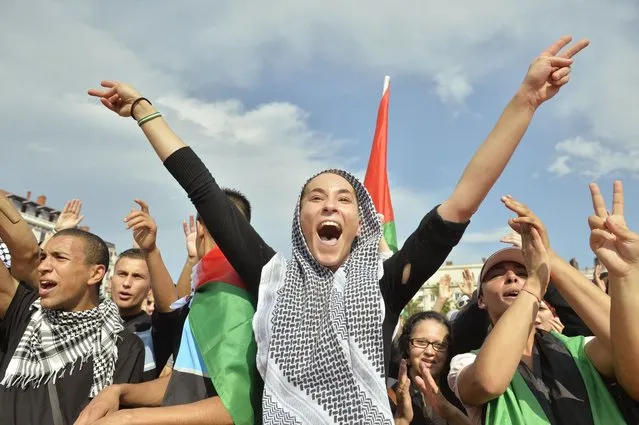 People shout slogans and flashes the V-sign during a demonstration in Lyon, central eastern France, on July 26, 2014 to protest against Israel's military campaign in Gaza and show their support for the Palestinian people. (Photo by Romain Lafabregue/AFP Photo)