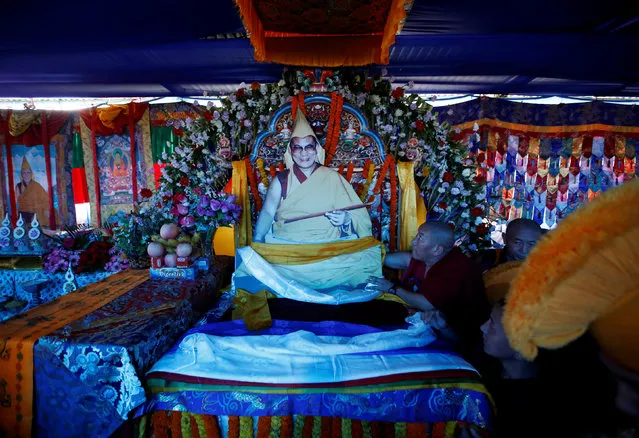 A Tibetan monk arranges a cardboard portrait of Dalai Lama during his birthday celebration in Kathmandu, Nepal, July 6, 2016. (Photo by Navesh Chitrakar/Reuters)