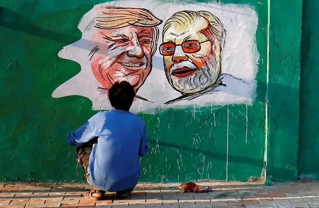 A man applies finishing touches to paintings of U.S. President Donald Trump and India's Prime Minister Narendra Modi on a wall as part of a beautification along a route that Trump and Modi will be taking during Trump's upcoming visit, in Ahmedabad, February 17, 2020. (Photo by Amit Dave/Reuters)