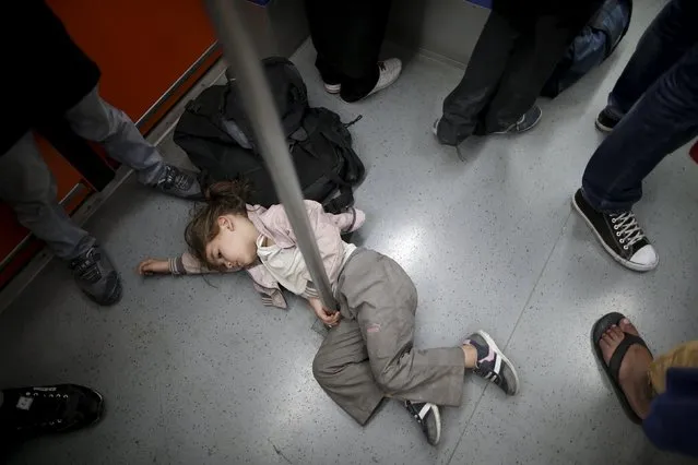 A Syrian refugee girl rests as she rides a Metro with relatives to central Athens after disembarking from a Greek ferry arriving from the island of Kos in the port of Piraeus, Greece, August 15, 2015. (Photo by Christian Hartmann/Reuters)