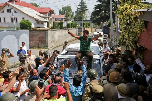A supporter of Mirwaiz Umar Farooq, a separatist political leader, shouts slogans atop a police vehicle during a protest in Srinagar against the recent killings in Kashmir, July 13, 2016. (Photo by Danish Ismail/Reuters)