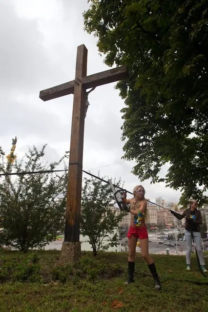 Ukraine FEMEN-activist Cuts Down Cross in Russian Female Punk Rock Band Protest