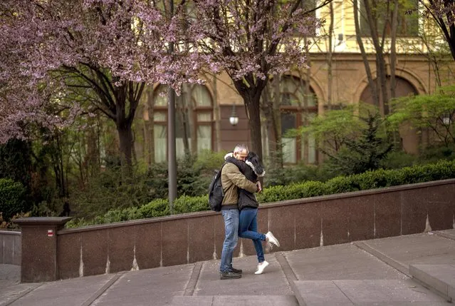 A couple embrace in central Kyiv, on Saturday, April 30, 2022. (Photo by Emilio Morenatti/AP Photo)