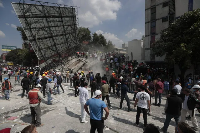 Rescue workers and volunteers search a building that collapsed after an earthquake in the Roma neighborhood of Mexico City, Tuesday, September 19, 2017. (Photo by Eduardo Verdugo/AP Photo)