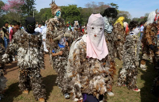 People dressed in suits with feathers and a masks take part in a religious festivity to honor Spanish missionary saint Francisco Solano in Emboscada, Paraguay, 24 July 2016. Dozens of “guaikurus” walk in honor of the saint in a procession in the Minas de Emboscada locality, a mix of indigenous tradition and catholic ritual. (Photo by Andres Cristaldo Benitez/EPA)