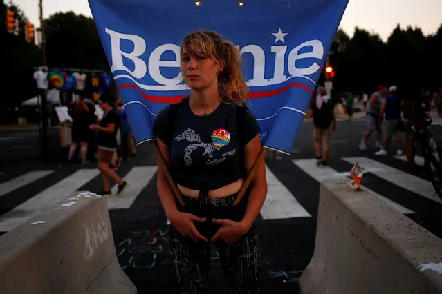 A woman on roller skates carries a flag supporting U.S. Senator Bernie Sanders along the perimeter walls of the 2016 Democratic National Convention in Philadelphia, Pennsylvania on July 27, 2016. (Photo by Adrees Latif/Reuters)