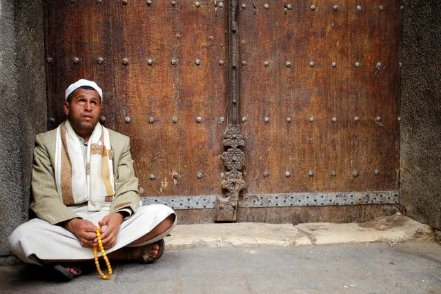A man sits in front of the gate of a mosque at the old quarter of the city of Sanaa, Yemen, July 24, 2016. (Photo by Mohamed al-Sayaghi/Reuters)