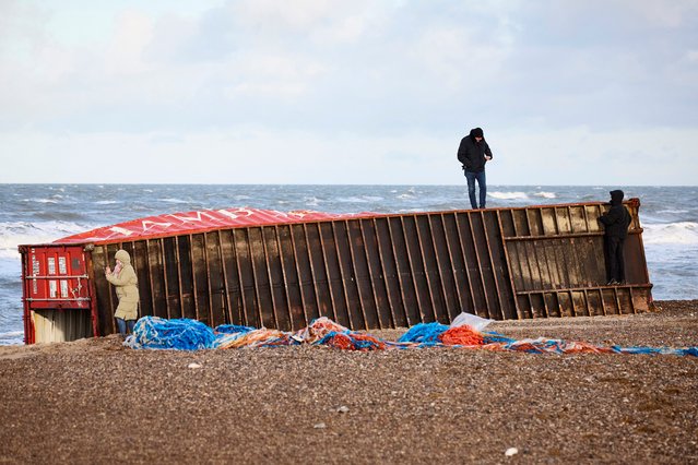 Visitors inspect a cargo container that was washed ashore on the Danish west coast at Tranum beach in North Jutland, Denmark on December 26, 2023. The contents of 46 containers were lost overboard from the ship Mayview Maersk during storm Pia and were washed ashore along the northern part of Denmark's North Sea shoreline. (Photo by Claus Bjoern Larsen/Ritzau Scanpix via AFP Photo)