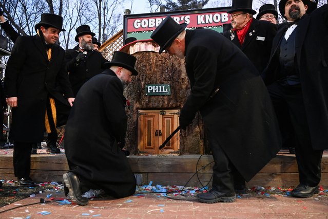 Groundhog Club President Tom Dunkel taps on Punxsutawney Phil's stump door, on the day groundhog Punxsutawney Phil makes his prediction on how long winter will last, during the Groundhog Day festivities, at Gobbler's Knob in Punxsutawney, Pennsylvania, on February 2, 2025. (Photo by Alan Freed/Reuters)