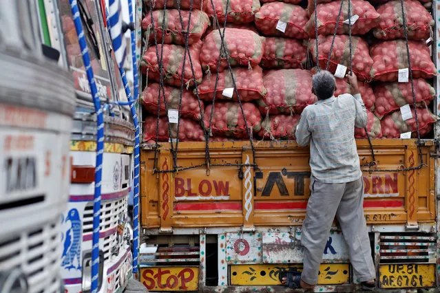 A labourer prepares to unload sacks of potatoes from a truck at a wholesale vegetable and fruit market in New Delhi July 2, 2014. (Photo by Anindito Mukherjee/Reuters)