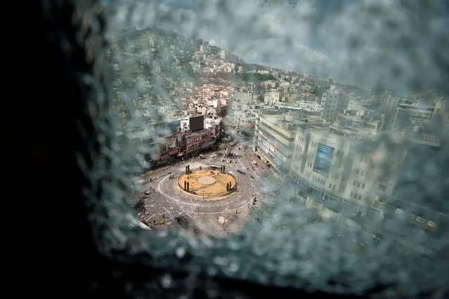 A roundabout is seen through a damaged window following clashes between Palestinian security forces and gunmen over the arrest of two Palestinian militants, in Nablus in the Israeli-occupied West Bank on September 20, 2022. (Photo by Mohamad Torokman/Reuters)