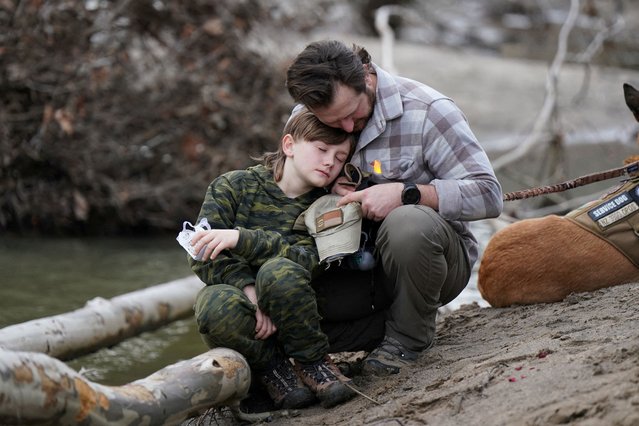 Jarrett Zeigler and his son Jaxon Zeigler attend a candlelight vigil for victims of Hurricane Helene in Green Mountain, North Carolina, on February 15, 2025. (Photo by Allison Joyce/Reuters)