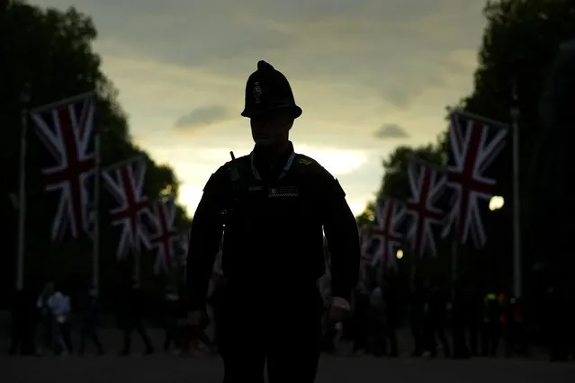 A police officer crosses the Mall on the eve of the funeral of Queen Elizabeth II in London, England, Sunday, September 18, 2022. Queen Elizabeth II, Britain's longest-reigning monarch and a rock of stability across much of a turbulent century, died Thursday Sept. 8, 2022, after 70 years on the throne. She was 96. (Photo by Petr David Josek/AP Photo)