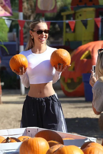Alexis Ren is all smiles as she shows up at the pumpkin patch in Los Angeles on October 21, 2022. Ren is seen with friends posing with pumpkins and searching for the best one. The Instagram model and actress wore a white crop top that showed off her abs with a flowing baggy workout pants and tennis shoes. (Photo by The Image Direct)