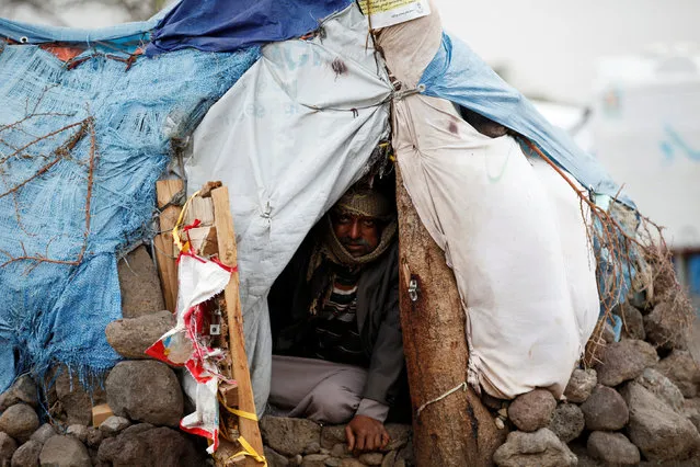 A man sits in his hut at a camp for internally displaced people near Sanaa, Yemen, August 10, 2016. (Photo by Khaled Abdullah/Reuters)