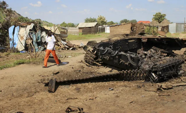 In this Saturday, July 16, 2016 file photo, a man walks past the remains of a tank destroyed during fighting between government and rebel forces on July 10, in the Jebel area of the capital Juba, South Sudan. A confidential U.N. report obtained by The Associated Press on Friday, September 9, 2016 says South Sudan's deadly fighting in July was directed by the highest levels of government, and that leaders are intent on a military solution that worsens ethnic tensions. (Photo by Samir Bol/AP Photo)