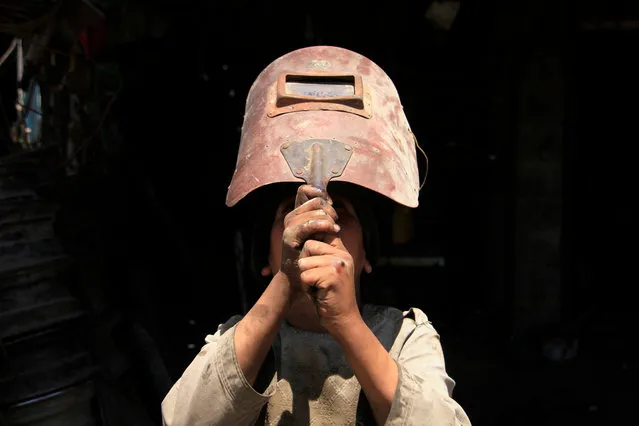 A boy uses a welding helmet to look at a partial solar eclipse in Ghazni, Afghanistan, 21 June 2020. Partial solar eclipse occurs when a portion of the Earth is engulfed by the shadow (penumbra) cast by the Moon as it passes between our planet and the Sun in imperfect alignment. During this annular eclipse – the first of the decade – the Moon appears to cover the Sun, leaving the Sun's halo as a visible rim forming an annulus, popularly known as the “ring of fire”. (Photo by Sayed Mustafa/EPA/EFE)