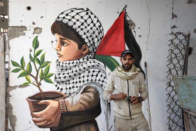 The Palestinian artist, who returned home after the ceasefire and hostage-prisoner swap deal between Hamas and Israel, paints pictures expressing determination, peace and hope on the rubble of houses as displaced Palestinians continue to return their houses in Rafah, Gaza on January 20, 2025. (Photo by Mahmoud Bassam/Anadolu via Getty Images)