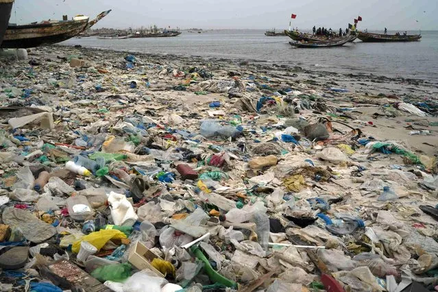 Trash and plastics litter the sand of Yarakh Beach in Dakar, Senegal, Tuesday, November 8, 2022. In 2020, Senegal passed a law that banned some plastic products. But if the mountains of plastic garbage on this beach are any indication, the country is struggling with enforcement. (Photo by Leo Correa/AP Photo)