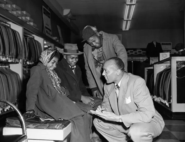 Jesse Owens, whose feats on the track have earned him the title of greatest track athlete the half-century in the Associated Press poll, autographs to admiring youngsters in a Chicago clothing store on January 25, 1950, where he is public relations and promotion man. (Photo by AP Photo)