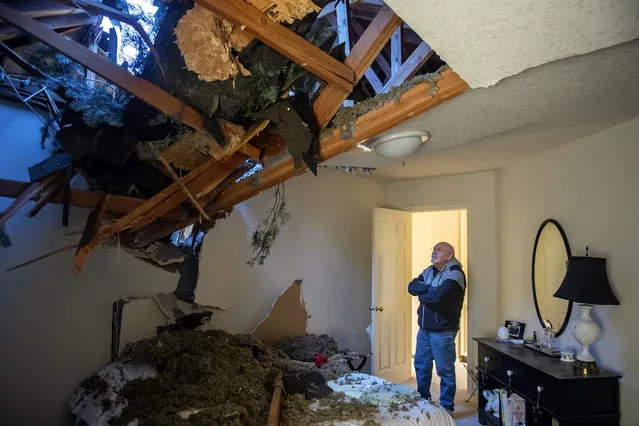 Bill Drummond looks over damage after high winds caused a tree to crash through two of his upstairs bedrooms the previous day in Hazel Dell, Wash., on Thursday, January 5, 2023. (Photo by Amanda Cowan/The Columbian via AP Photo)