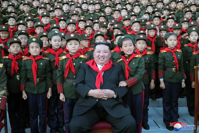 A photo released by the official North Korean Central News Agency (KCNA) shows North Korean leader Kim Jong-un (C) posing for a photograph with students while attending a ceremony to mark the 75th anniversary of the Mangyongdae Revolutionary School and Kang Pan Sok Revolutionary School in Pyongyang, North Korea, 12 October 2022. (Photo by KCNA/EPA/EFE)
