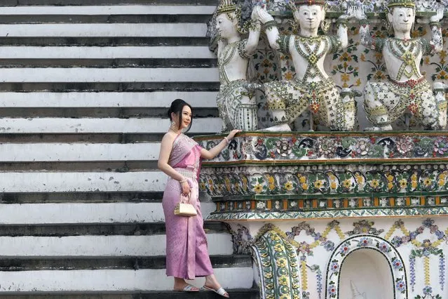 A Chinese tourist in traditional Thai dress poses for a photograph at Wat Arun or the “Temple of Dawn” in Bangkok, Thailand on January 12, 2023. A hoped-for boom in Chinese tourism in Asia over next week’s Lunar New Year holidays looks set to be more of a blip as most travelers opt to stay inside China if they go anywhere. (Photo by Sakchai Lalit/AP Photo)