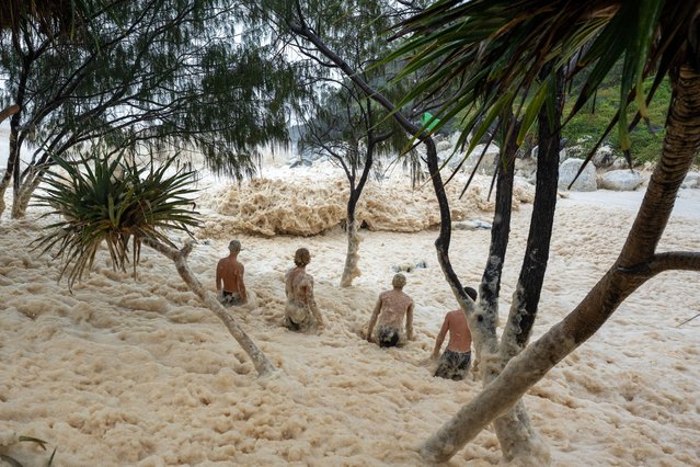 A group walk into the sea form caused by crashing waves on March 07, 2025 in Tweed Heads, Australia. Australia's east coast, particularly Queensland and northern New South Wales, is bracing for the impact of Tropical Cyclone Alfred, a rare Category 2 storm that is expected to make landfall between the Gold Coast and southern parts of the Wide Bay region. The cyclone is anticipated to bring damaging winds, heavy rainfall, and severe flooding, with millions of residents preparing for the worst-case scenario. Authorities have issued evacuation orders, distributed sandbags, and shut down airports and public transport in anticipation of the storm's arrival, which could be one of the most significant weather events in the region in decades. (Photo by Asanka Ratnayake/Getty Images)