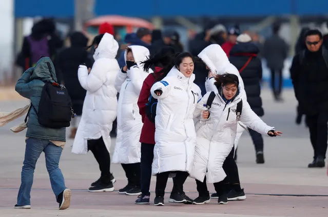 Staff from Olympic Park struggle to walk during the wind in Gangneung, South Korea on February 14, 2018. Officials are asking spectators to evacuate the Olympic Park in the coastal city of Gangneung and take shelter indoors because of strong winds. (Photo by John Sibley/Reuters)