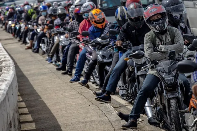 A long line of motorcycle riders form at a quarantine checkpoint on the first day of a reimposed lockdown to curb the spread of COVID-19, on August 4, 2020 in Quezon city, Metro Manila, Philippines. President Rodrigo Duterte has reimposed a strict lockdown in capital Manila and surrounding provinces as the country continues to struggle with rising coronavirus infections which has breached 100,000 cases. Duterte's move came after nearly 100 medical organizations representing 80,000 doctors and a million nurses called for tighter controls and warned that the country's health systems has been overwhelmed by the surge of cases and are close to collapsing as health workers fall ill or resign out of fear and exhaustion. (Photo by Ezra Acayan/Getty Images)