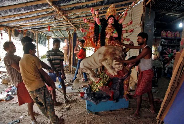 Artisans pull an idol of Hindu goddess Durga from a workshop to load it onto a truck ahead of the Durga Puja festival, in Chandigarh, India, October 3, 2016. (Photo by Ajay Verma/Reuters)