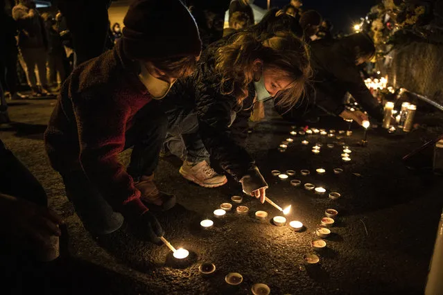 Children light candles as people gather for Kevin Peterson Jr., who was killed in Thursday's shooting with police involved, at a candlelight vigil in Vancouver, Wash., Friday, October 30, 2020. The Clark County Sheriff's office has not released any details on the Thursday evening shooting in Hazel Dell, but a man told The Oregonian/OregonLive that his 21-year-old son was fatally shot by police. (Photo by Paula Bronstein/AP Photo)
