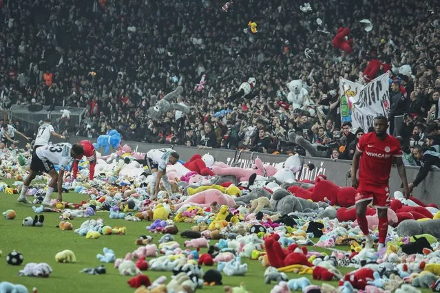 Fans throw toys onto the pitch during the Turkish Super League soccer match between Besiktas and Antalyaspor at the Vodafone stadium in Istanbul, Turkey, Sunday, February 26, 2023. During the match, supporters threw a massive number of soft toys to be donated to children affected by the powerful earthquake on Feb. 6 on southeast Turkey. (Photo by AP Photo/Stringer)