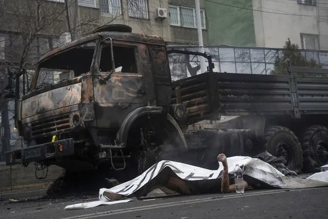 A body of victim laying near a military truck, which was burned after clashes, is seen in Almaty, Kazakhstan, Thursday, January 6, 2022. Kazakhstan's president authorized security forces on Friday to shoot to kill those participating in unrest, opening the door for a dramatic escalation in a crackdown on anti-government protests that have turned violent. The Central Asian nation this week experienced its worst street protests since gaining independence from the Soviet Union three decades ago, and dozens have been killed in the tumult. (Photo by Vladimir Tretyakov/NUR.KZ via AP Photo)